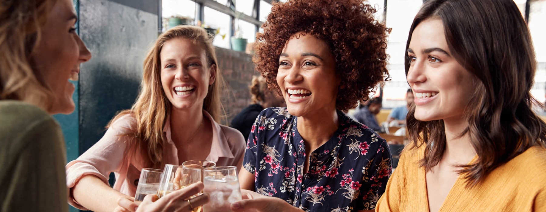 a group of women sitting at a table with food